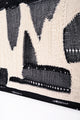 Layered textile detail showing hand knit, crocheted, and mesh elements in tonal black and cream abstract composition