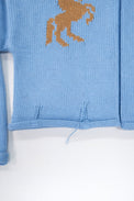 Hem detail of baby blue cotton cropped knit jacket with rolled edge finish
