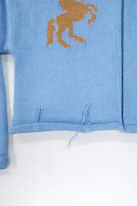 Hem detail of baby blue cotton cropped knit jacket with rolled edge finish