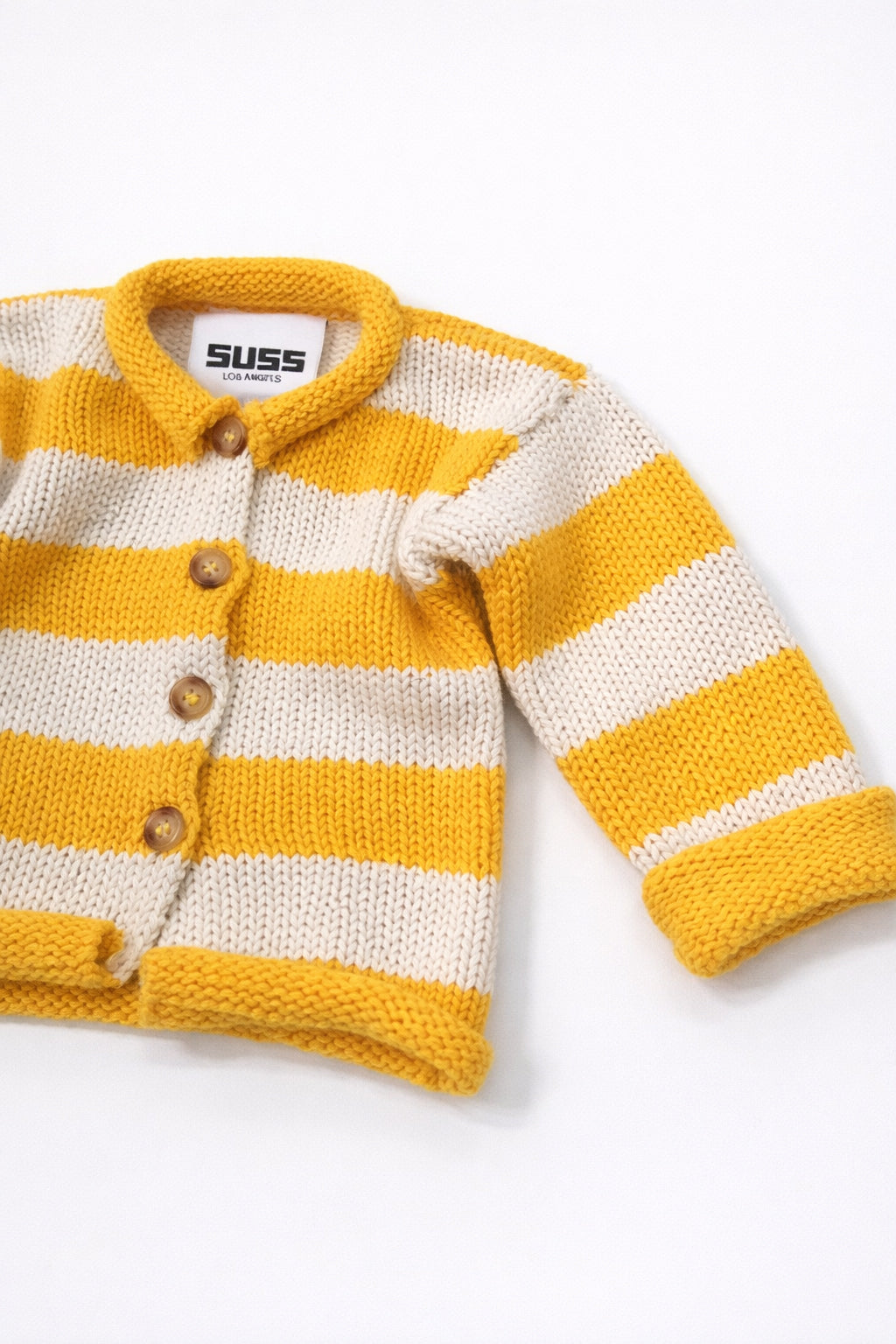 Angled view of cotton yellow striped baby knit cardigan showing texture detail