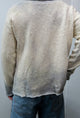 Back view on male model of the archive finish raglan sweater knit in 100% cotton.