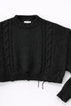 Close up of sleeve on black cropped knit sweater showing texture and distressed stitch details