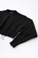 Close up of sleeve on black cropped knit sweater showing angle texture and distressed stitch detail