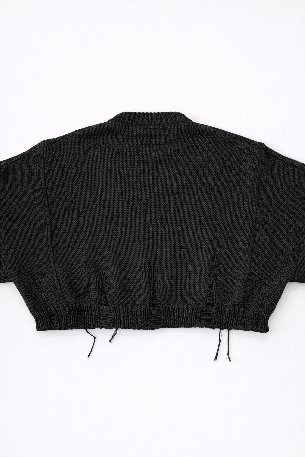 Back view of bright black cropped knit sweater with ribbed hem and subtle distressing