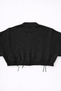 Back view of bright black cropped knit sweater with ribbed hem and subtle distressing