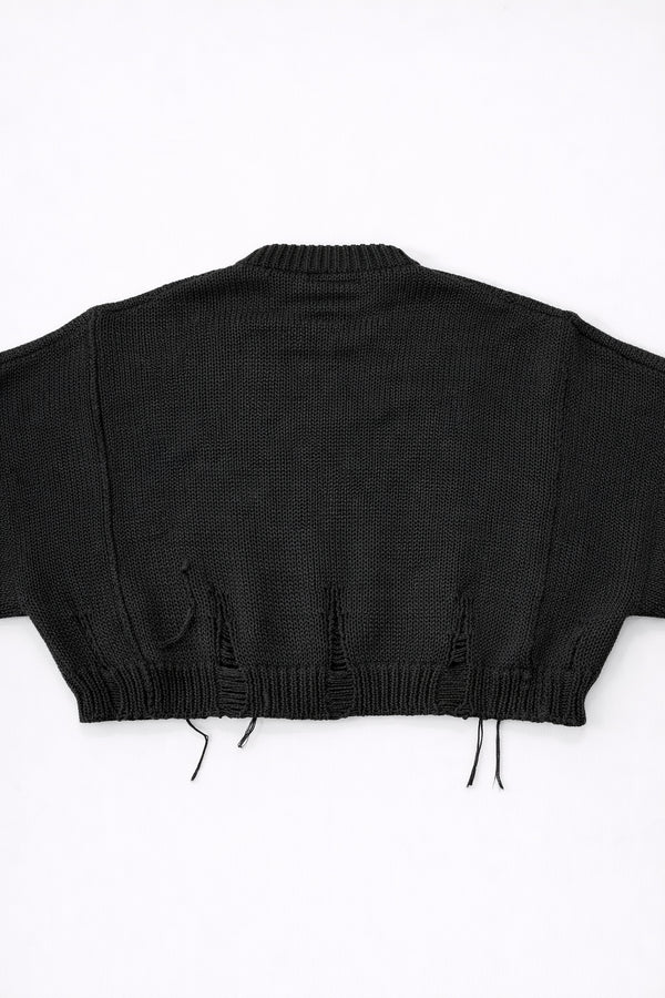 Back view of bright black cropped knit sweater with ribbed hem and subtle distressing