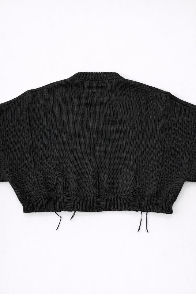 Back view of bright black cropped knit sweater with ribbed hem and subtle distressing