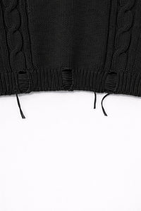 Distressed ribbed hem with drop stitches on bright black cropped knit sweater