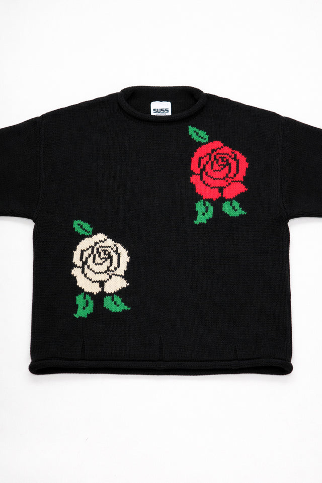 Front view close-up of red rose and cream rose intarsia knit detail on black cotton sweater by Suss Knits