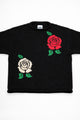 Front view close-up of red rose and cream rose intarsia knit detail on black cotton sweater by Suss Knits