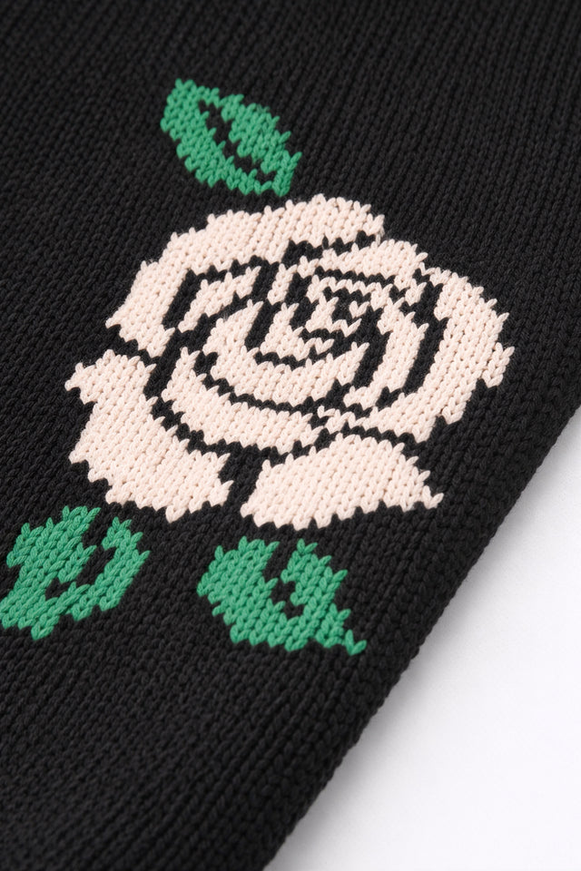 Close-up of red rose intarsia knit detail on black cotton sweater by Suss Knits