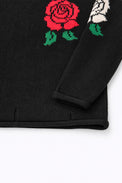 Sleeve and hem detail of black cotton knit sweater with rose intarsia by Suss Knits