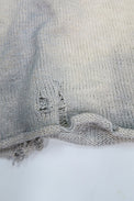Close up detail of distressing and dye on the suss knits archive finish raglan sweater.