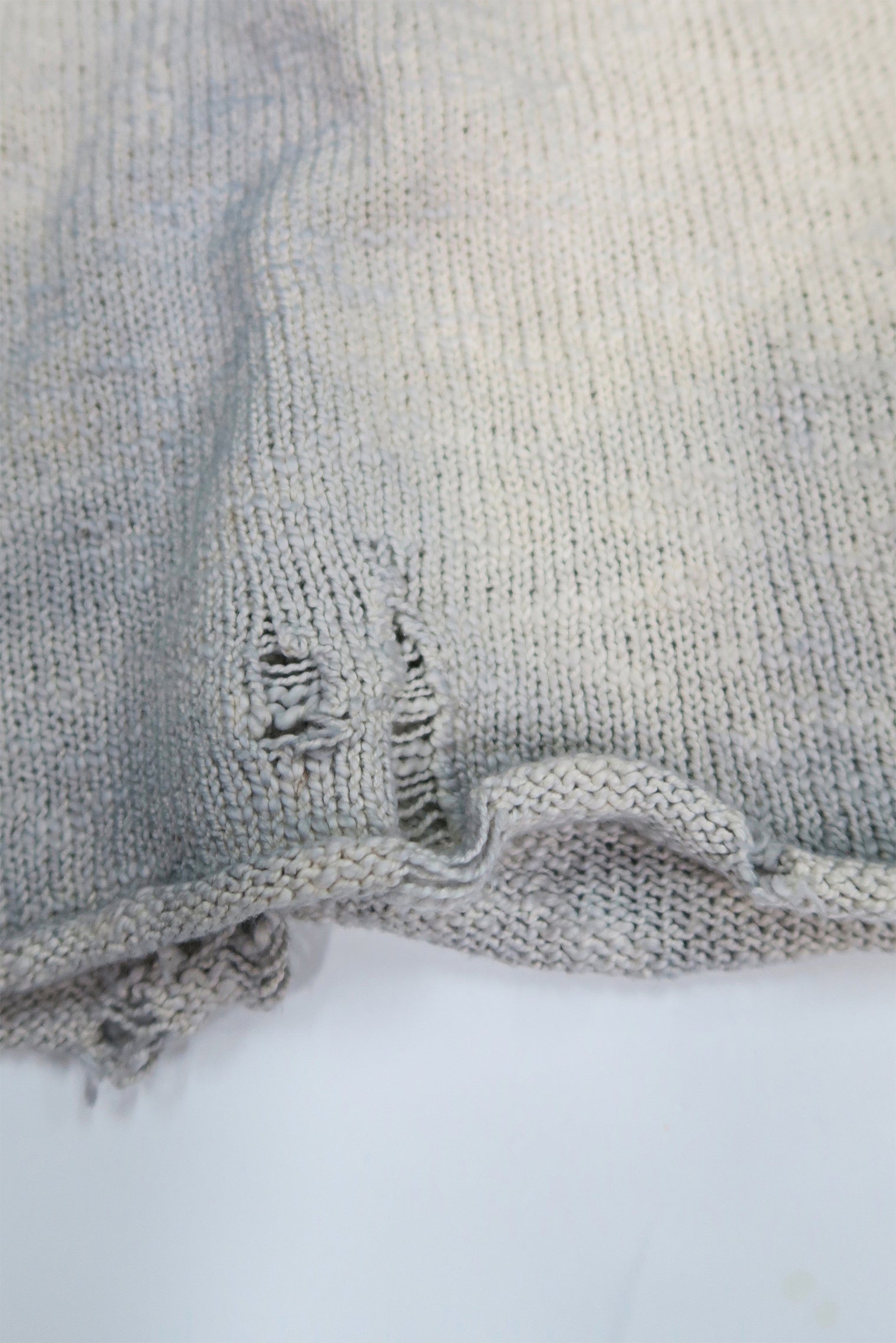 Close up detail of distressing and dye on the suss knits archive finish raglan sweater.