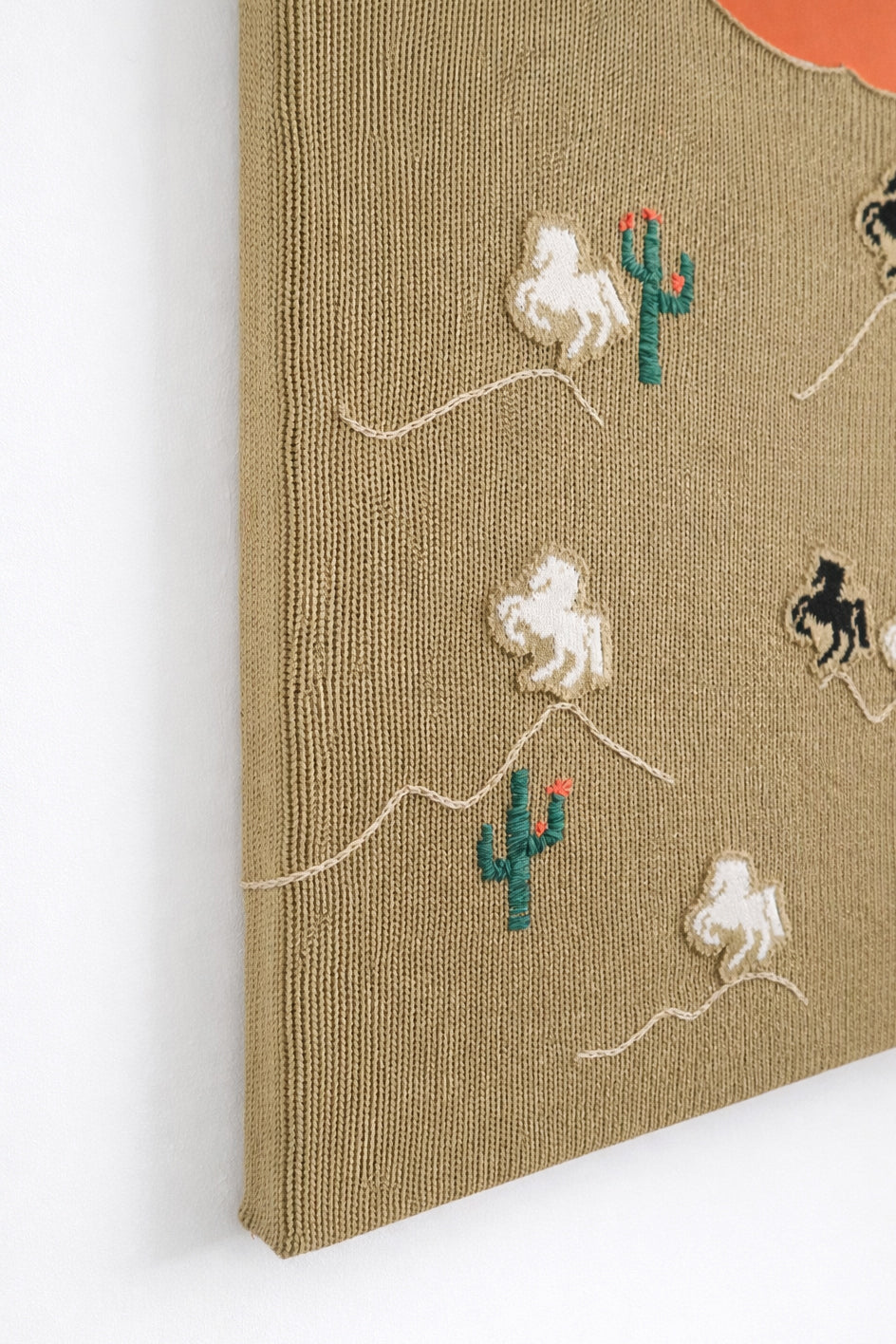 suss knits left angle detail of hand loomed horse appliqués sewn onto knit textile panel