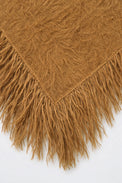 Close-up of texture and long hand-knit fringe on camel fuzzy knit poncho by Suss Knits