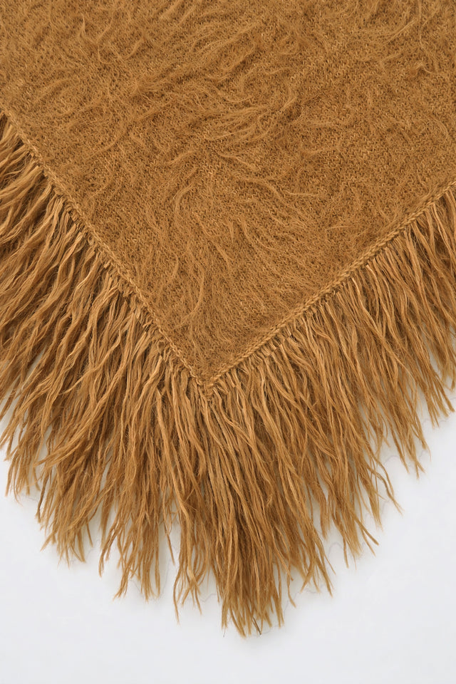 Close-up of texture and long hand-knit fringe on camel fuzzy knit poncho by Suss Knits