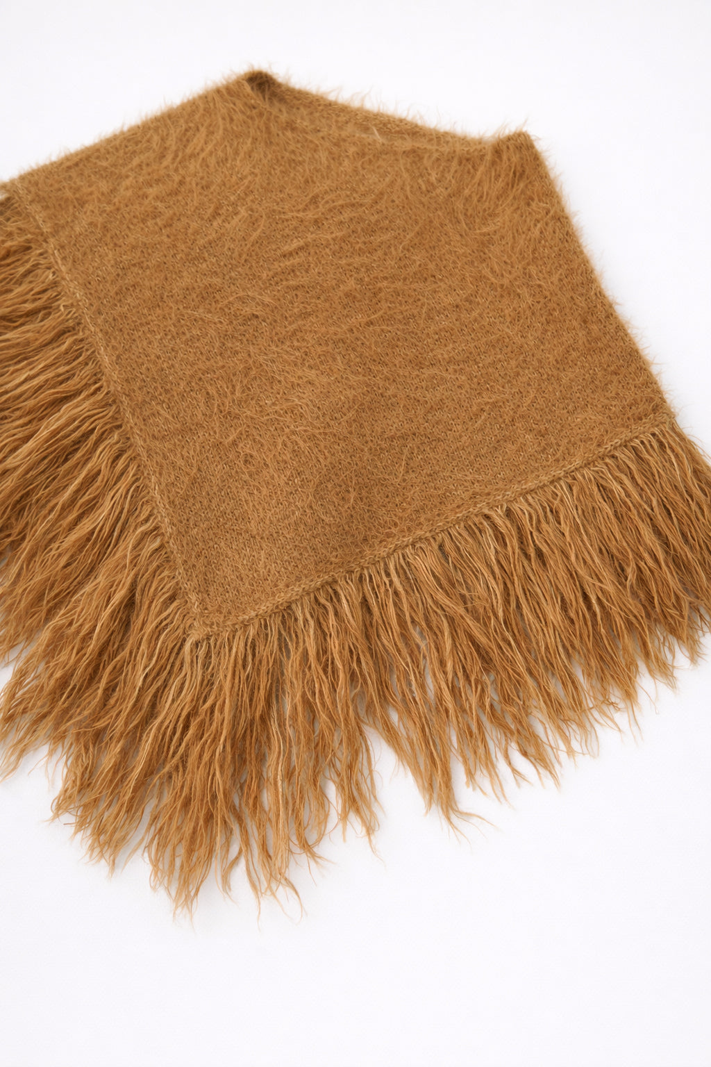 Camel fuzzy knit poncho with fringe shown at an angle by Suss Knits