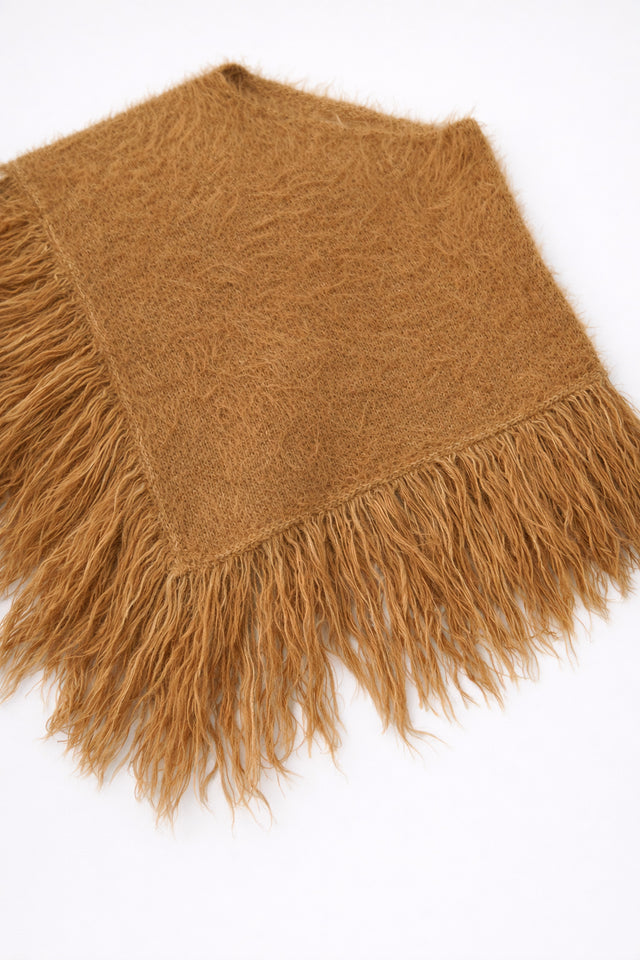 Camel fuzzy knit poncho with fringe shown at an angle by Suss Knits