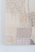Mixed knit stitch patterns including seed stitch and box stitch in neutral patchwork textile art in cream knit in Los Angeles