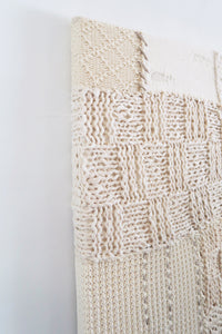 Lace knit and wool box stitch detail in handcrafted textile artwork made from cotton and cashmere yarns