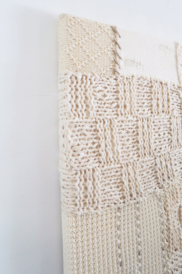 Lace knit and wool box stitch detail in handcrafted textile artwork made from cotton and cashmere yarns