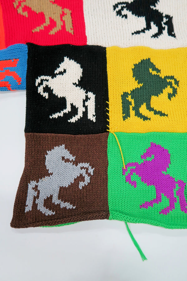 Close-up of multiple horse intarsia knit panels with raw edge seam and side slit detail