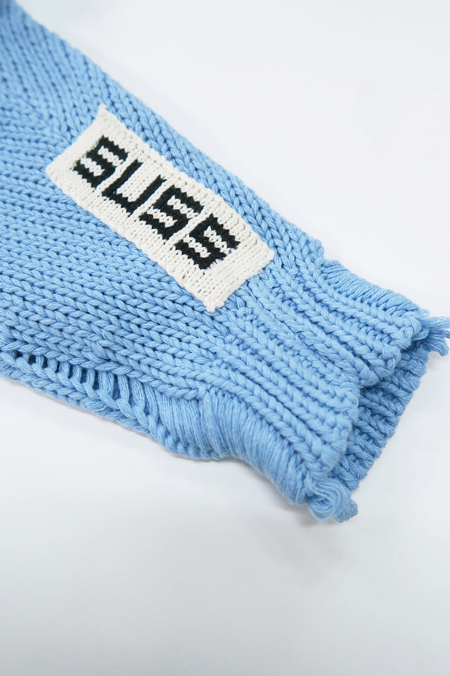 Subtle hand loomed SUSS logo on wrist seam of oversized knit sweater