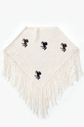A cropped poncho knit in recycled cotton, cream base with brown and black horse motifs and long fringe