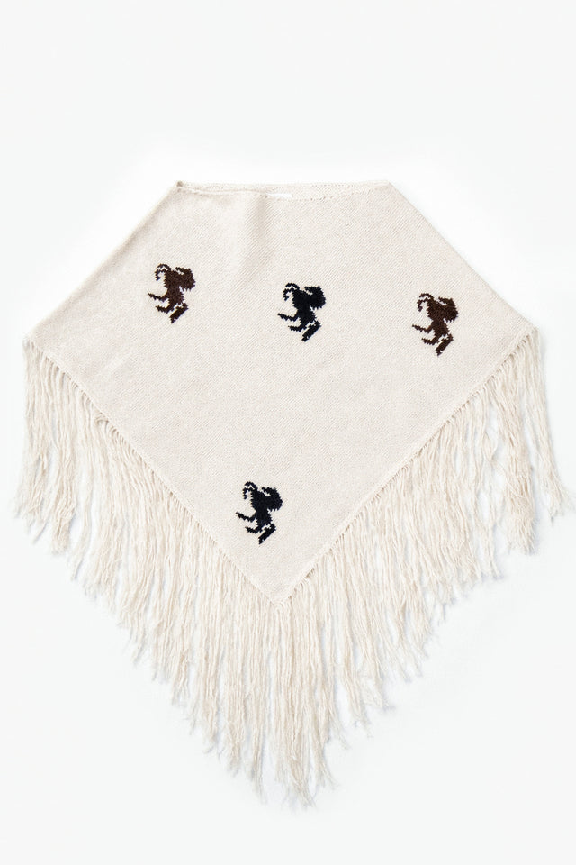 A cropped poncho knit in recycled cotton, cream base with brown and black horse motifs and long fringe