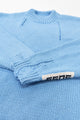Close-up of ribbed cuff with handmade drop stitch detail on blue knit sweater