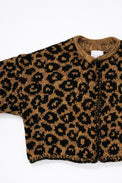 Armhole detail of leopard knit cardigan showing texture and construction