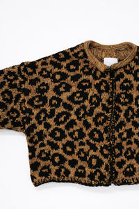 Armhole detail of leopard knit cardigan showing texture and construction