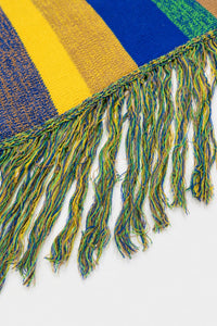 Close-up of layered multicolor fringe strands on striped recycled cotton poncho