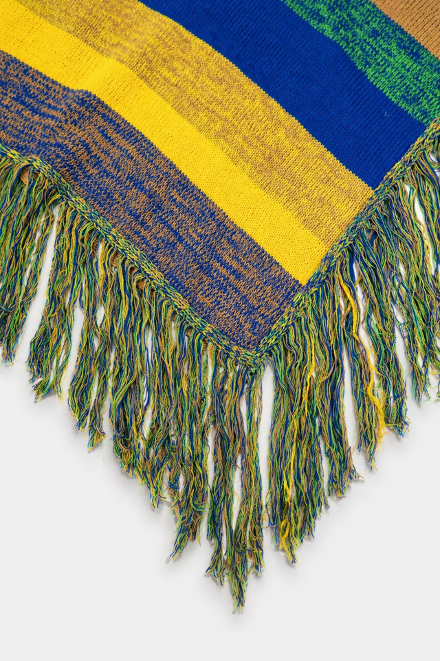 Detailed view of multicolor fringe on hand loomed striped poncho in recycled cotton