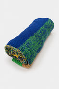 Rolled striped poncho showing knit texture and color variation in recycled cotton