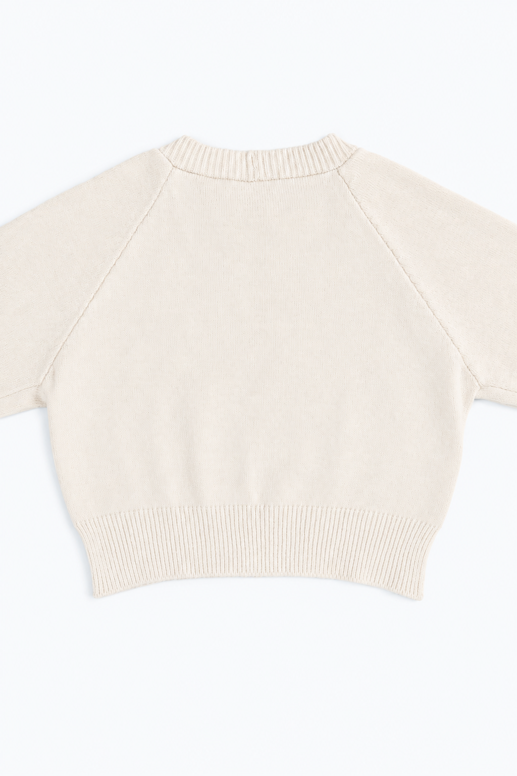 The Suss Knits Cream Open Raglan Knit Top detail shot of back panel with ribbed hem knit in cotton and lycra