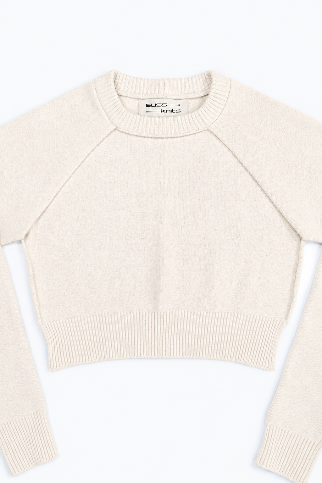 The Suss Knits Cream Open Raglan Knit Top front detail with open sides and raglan sleeves with view of ribbed neckline in cotton