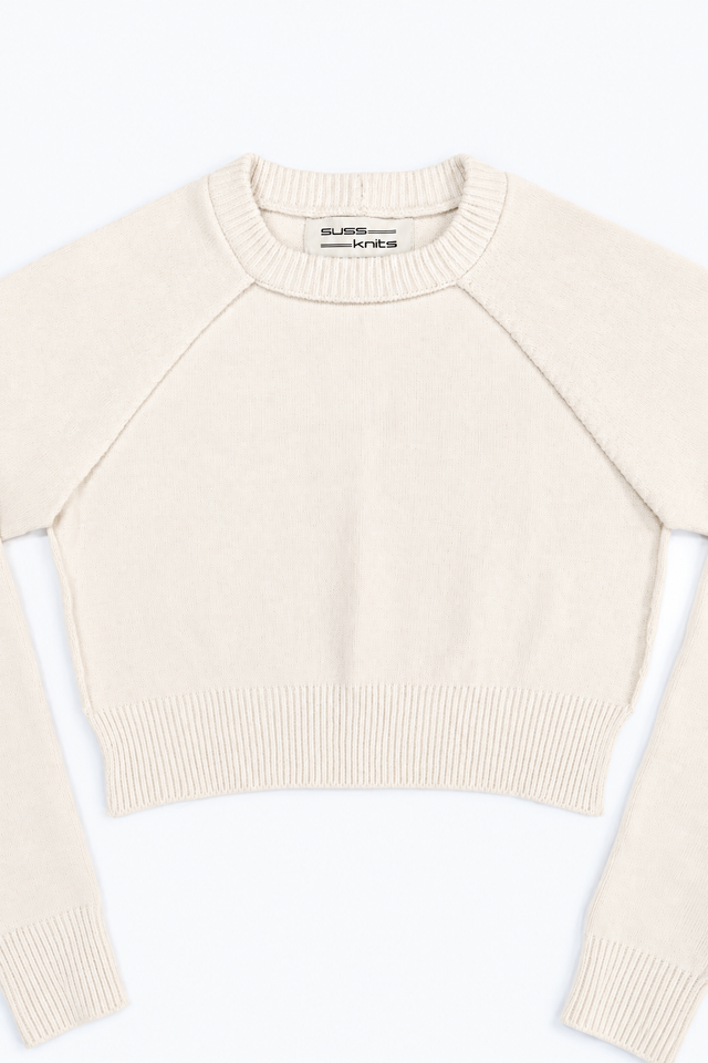 The Suss Knits Cream Open Raglan Knit Top front detail with open sides and raglan sleeves with view of ribbed neckline in cotton
