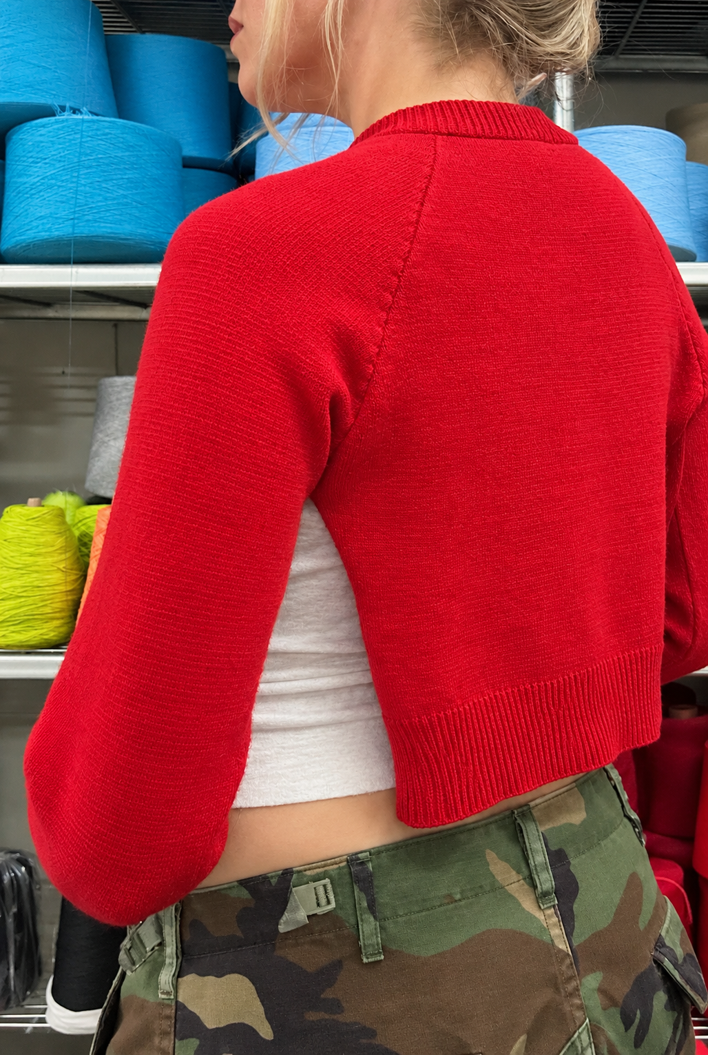 A woman shown from the back wearing the Suss Raglan Open Knit Top in bright red