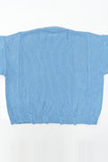 Back view of oversized blue knit sweater showing three panel construction and relaxed silhouette