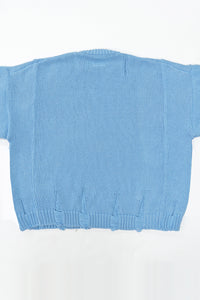 Back view of oversized blue knit sweater showing three panel construction and relaxed silhouette