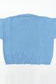 Back view of oversized blue knit sweater showing three panel construction and relaxed silhouette