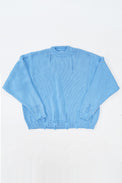 Oversized blue knit sweater flatlay by Suss Knits with wide fit and distressed ribbed hem
