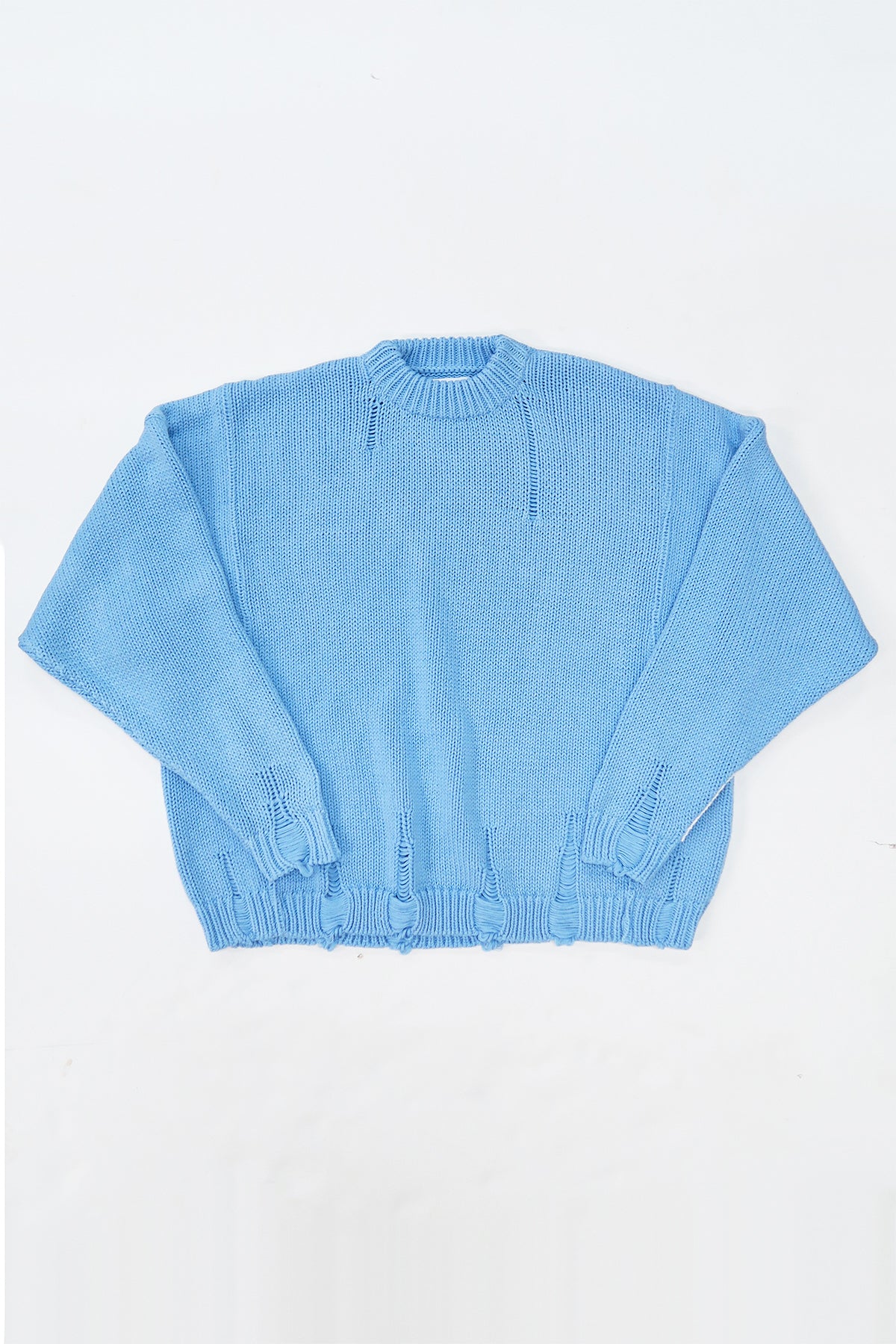 Oversized blue knit sweater flatlay by Suss Knits with wide fit and distressed ribbed hem