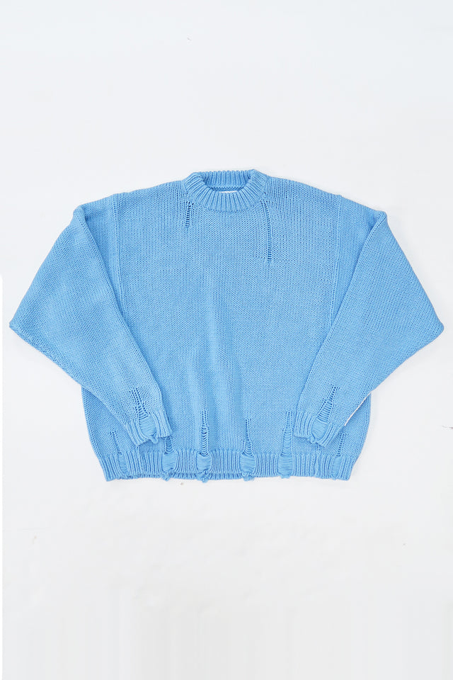 Oversized blue knit sweater flatlay by Suss Knits with wide fit and distressed ribbed hem