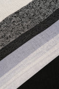 Detailed knit texture of black and grey striped poncho fabric