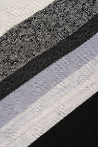 Detailed knit texture of black and grey striped poncho fabric