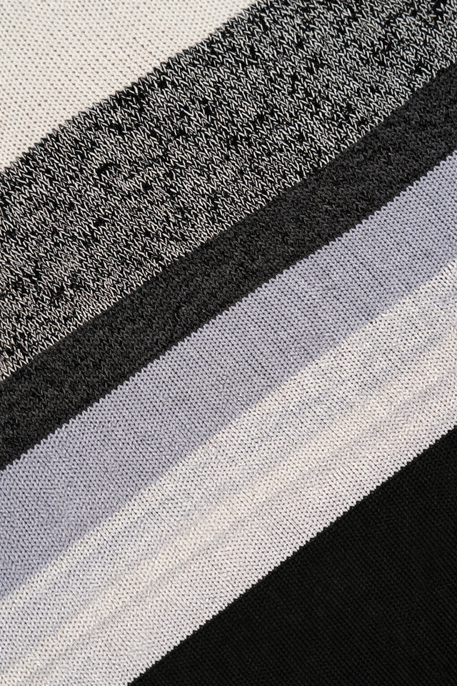 Detailed knit texture of black and grey striped poncho fabric