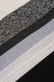 Detailed knit texture of black and grey striped poncho fabric